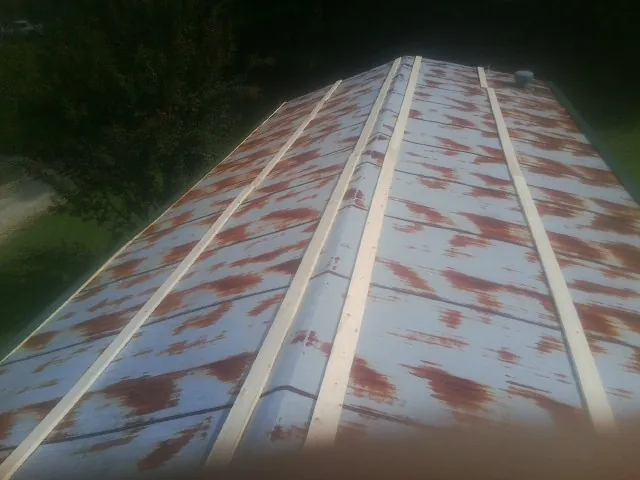 Rusted metal roof panels with new wood purlins before replacement — Storm Damage Roof Repair in Goodells by Roofing Brothers