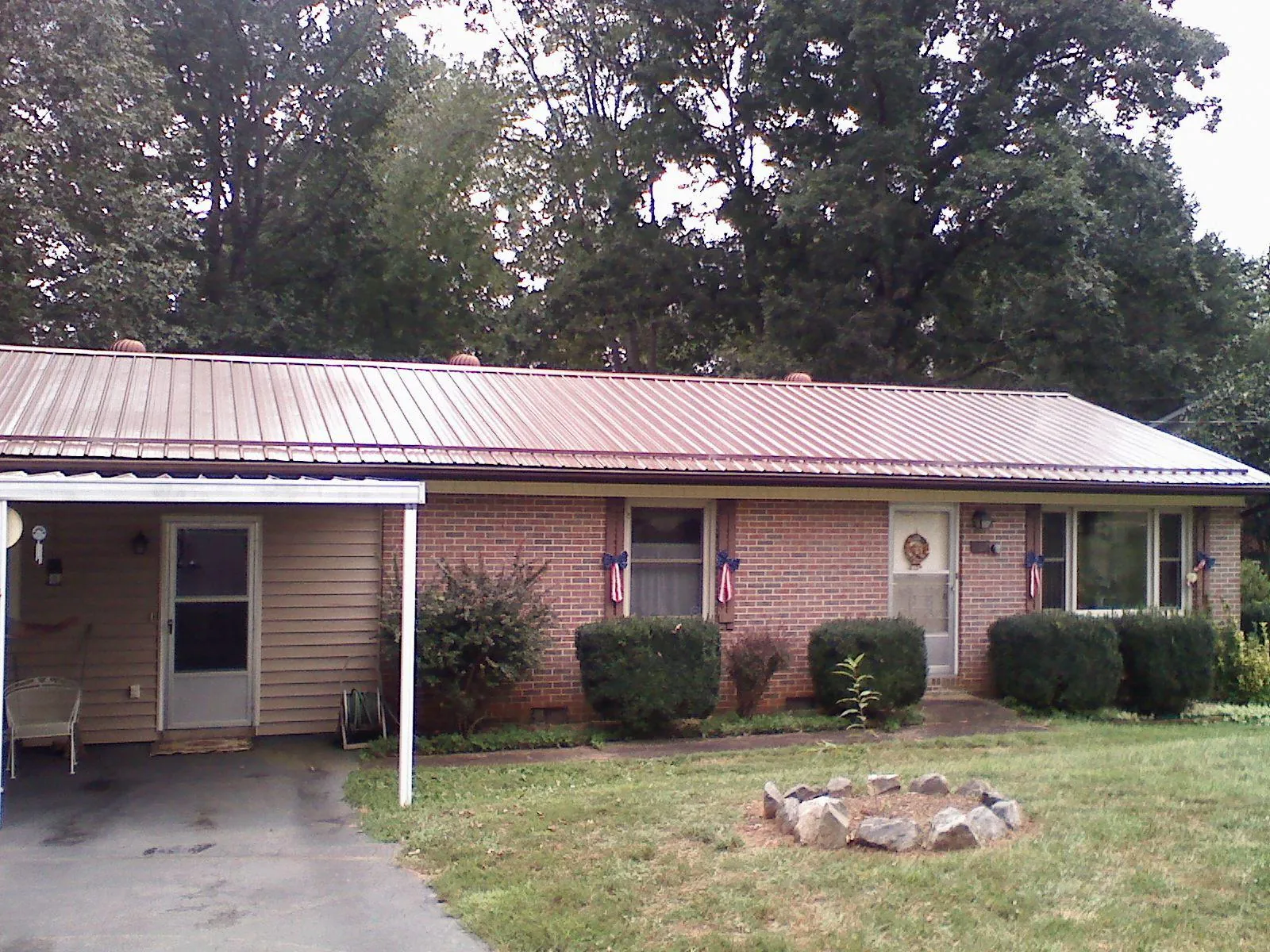 Bronze metal roof and carport on a brick ranch home — Roof Repair work by our crew in Goodells